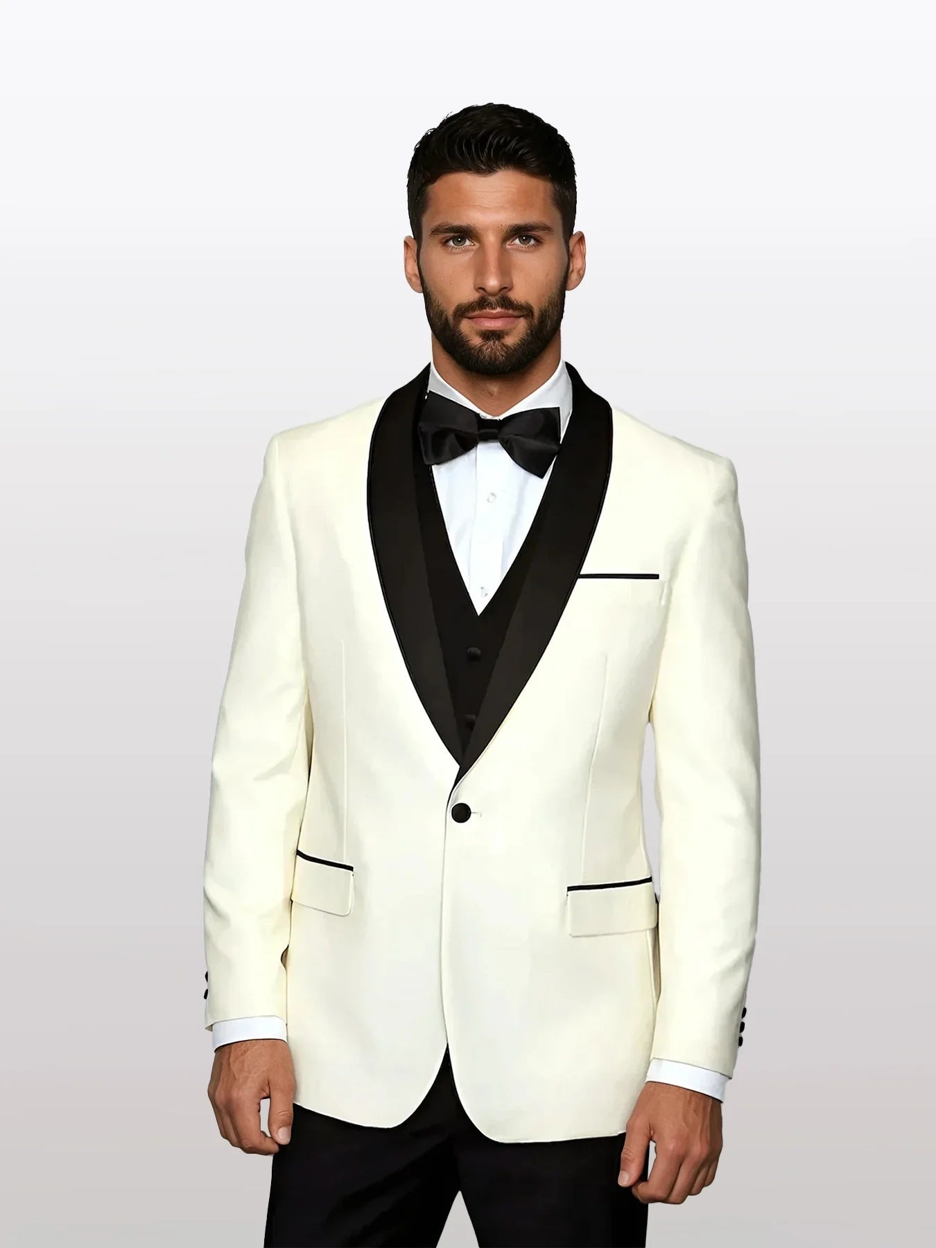 The mens ivory tuxedo has a fitted shape with a black satin lapel, 100% wool fabric, and features a single button closure. It includes black pocket accents and is paired with a black bow tie.