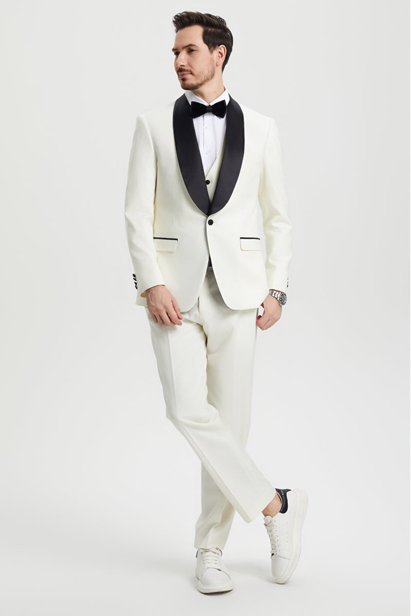 Ivory Stacy Adams one-button tuxedo with shawl lapel. Fitted shape, matching vest, and contrasting black lapel/pocket accents. Tailored trousers complete the look.