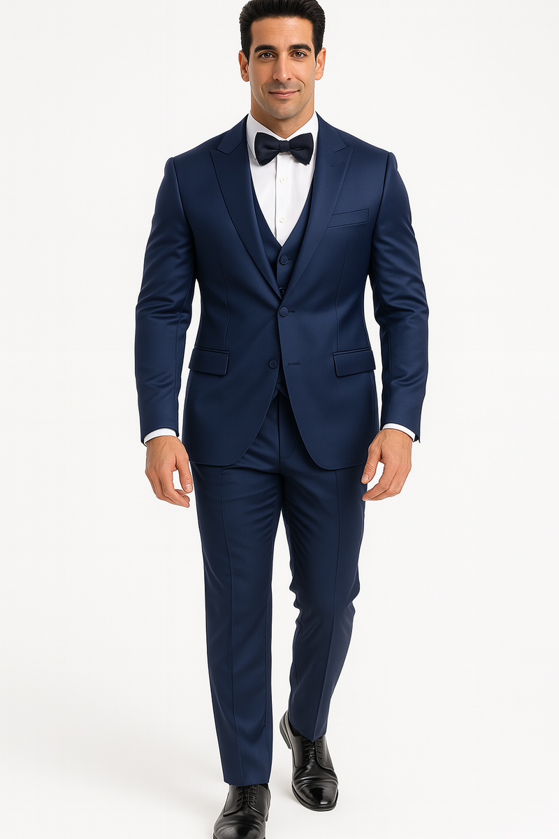 Alberto Nardoni's blue tuxedo set: single-breasted jacket with peak lapel, matching trousers, and vest. Deep blue, smooth finish, white shirt, black bow tie. Straight-leg, fitted pants. Lightweight, slightly shiny fabric. Formal.