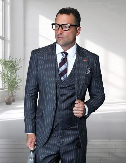The Statement mens 100% wool pinstripe 3-piece suit features a peak lapel design, primarily in dark navy with thin white pinstripes. The suit consists of a tailored jacket, matching vest, and trousers, showcasing a structured fit. The materials exhibit a smooth texture, indicative of wool fabric.