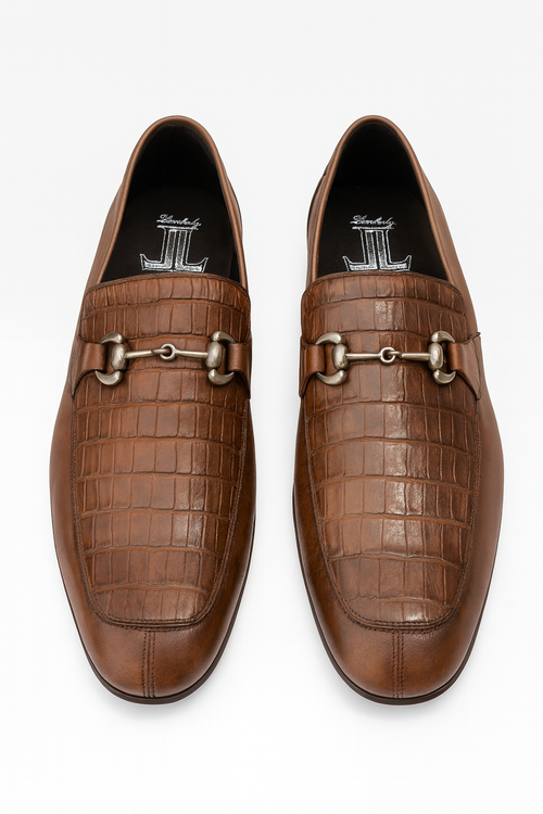 Brown slip-on men's shoes with crocodile-patterned leather and a metallic horsebit. Structured yet elegant, with a rounded toe and low, cushioned heel for comfort.