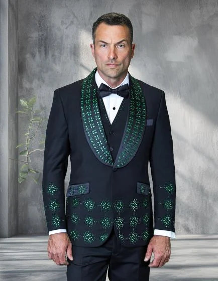 The Statement men's 3-piece modern fit tuxedo features a black base with embellished rhinestones arranged in a floral pattern on the jacket. The shawl lapel is adorned with green rhinestones, complementing the overall design. The tuxedo includes a vest and trousers.
