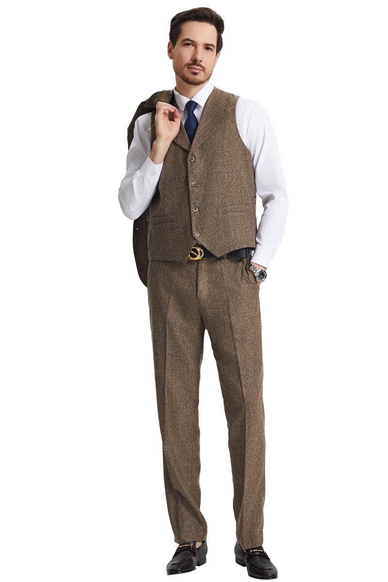 Light brown vintage herringbone tweed Stacy Adams suit. Features a three-button vest with two pockets and matching tapered trousers. Textured fabric for a sophisticated, traditional look. Includes jacket over the shoulder.