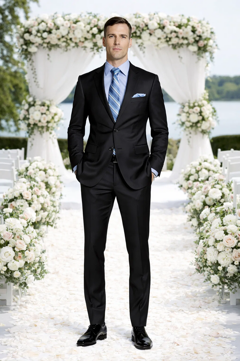 Giorgio Fiorelli black suit with French blue shirt. Tailored black jacket with notch lapels, matching trousers. Light blue shirt, striped tie, pocket square. Fitted, modern silhouette.