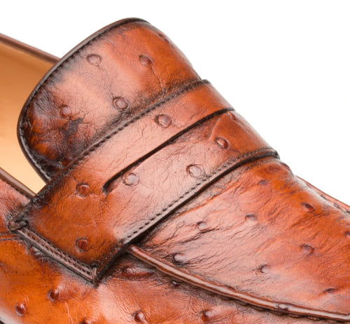 Mezlan Lisbon slip-on crafted from textured brown ostrich leather. Features a smooth, rounded toe and elegant vamp strap. Distinctive bumps add character.