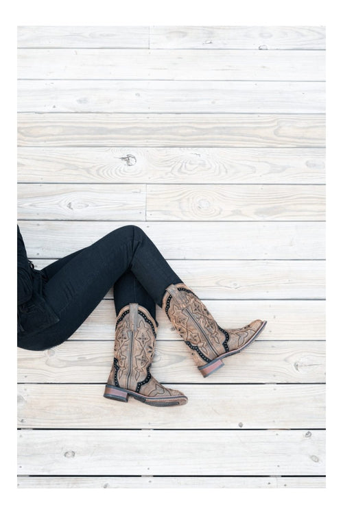 Laredo women's brown leather boots with a broad square toe, tall shaft, and decorative stitching, including star patterns. Featuring a durable sole and contrasting leather accents with studs.