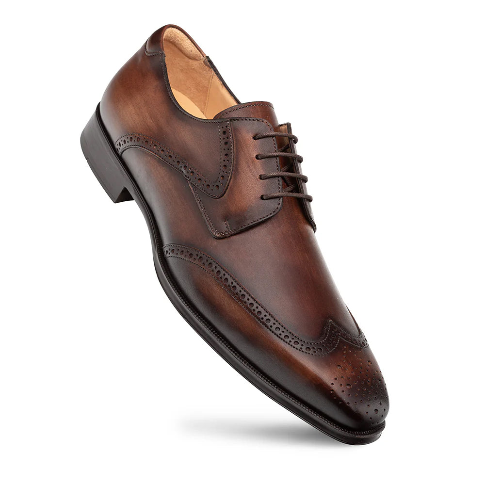 Mezlan Tasso Wing Tip Derby in chestnut. Polished leather, rich brown, classic wingtip design with broguing. Rounded toe, five-eyelet lace-up, contrasting sole for durability and style.