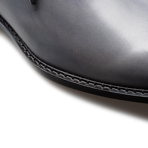 Mezlan Barbaro Oxford: Two-tone design with grey leather upper and black cap toe. Sleek, rounded shape with side curvature and stitched seam detailing for enhanced structure.