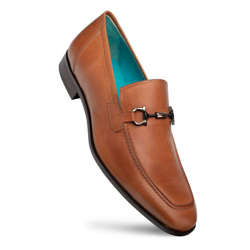Mezlan Rios Flex Loafer in cognac. Smooth leather upper, tapered shape, and decorative metal ornament. Features contrasting turquoise lining and a stable black rubber sole.