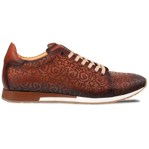 Mezlan Portico laser print sneaker in cognac rust leather. Rounded toe, swirling pattern, light beige laces. Lightweight sole with white stripe & tan base. Smooth cognac leather heel.
