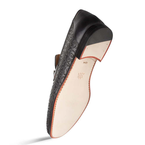 Black Mezlan Alcaraz slip-on with laser-cut detailing. Features a rounded toe, low profile, and contrasting light sole with a slight heel.