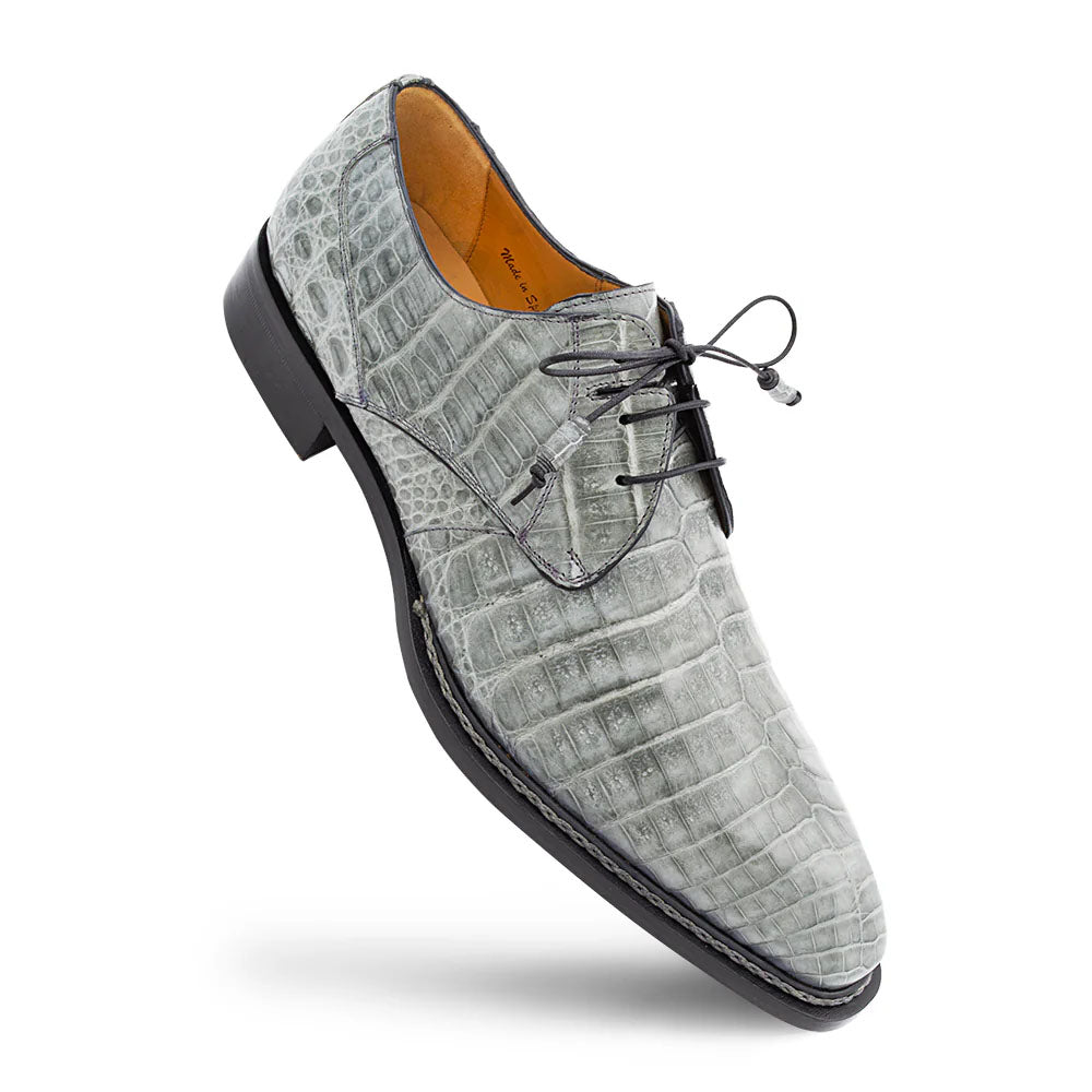 Mezlan Cratos Derby in pearl grey, crocodile-embossed leather with a structured derby shape and pointed toe. Features lace-up closure and low-profile black rubber sole. Distinct crocodile skin texture.