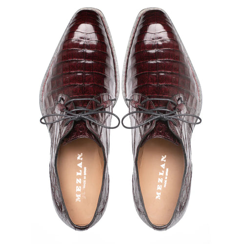 Mezlan Cratos Derby: Burgundy crocodile leather, elongated shape, glossy finish, textured pattern. Black laces, light lining. Pointed design.