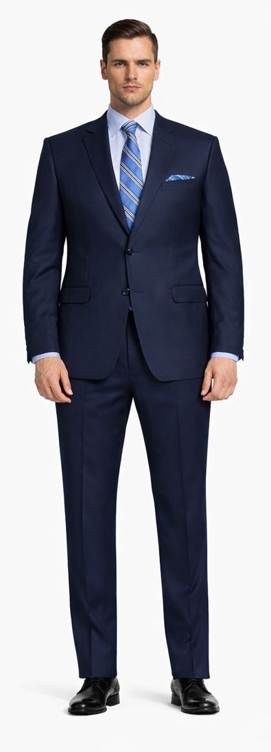Dark navy two-button suit: slim/modern fit. Tailored jacket, straight-cut pants. Smooth fabric, formal wear. Worn with light blue shirt, blue patterned tie, and pocket square.