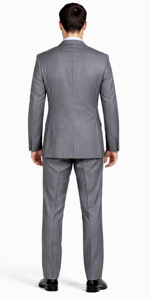 Mantoni gray wool suit: tailored silhouette, two-button jacket with notch lapels, single vent. Light gray, subtle texture. Trousers taper slightly at the ankle. Super 100s wool.