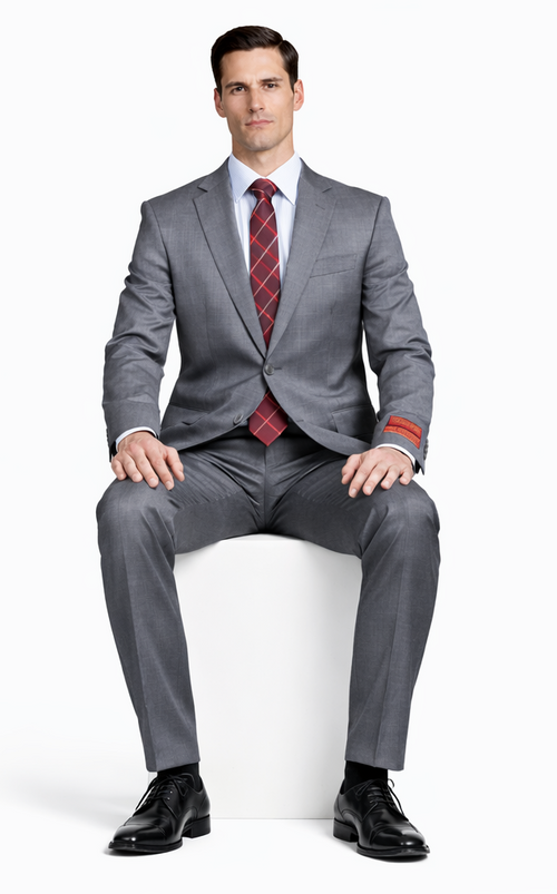 Mantoni gray super wool suit: tailored fit, straight silhouette. Features two-button jacket with notched lapel. Includes matching trousers, red/white checkered tie, and black dress shoes for a formal look.