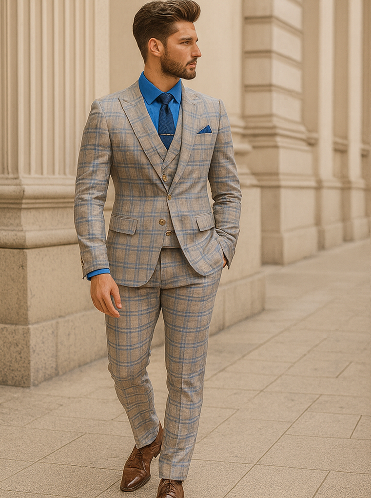 Blue & beige plaid suit with vest & gold buttons. Light fabric, tailored jacket with peaked lapel, slim pants. Blue dress shirt & pocket square complete the look.