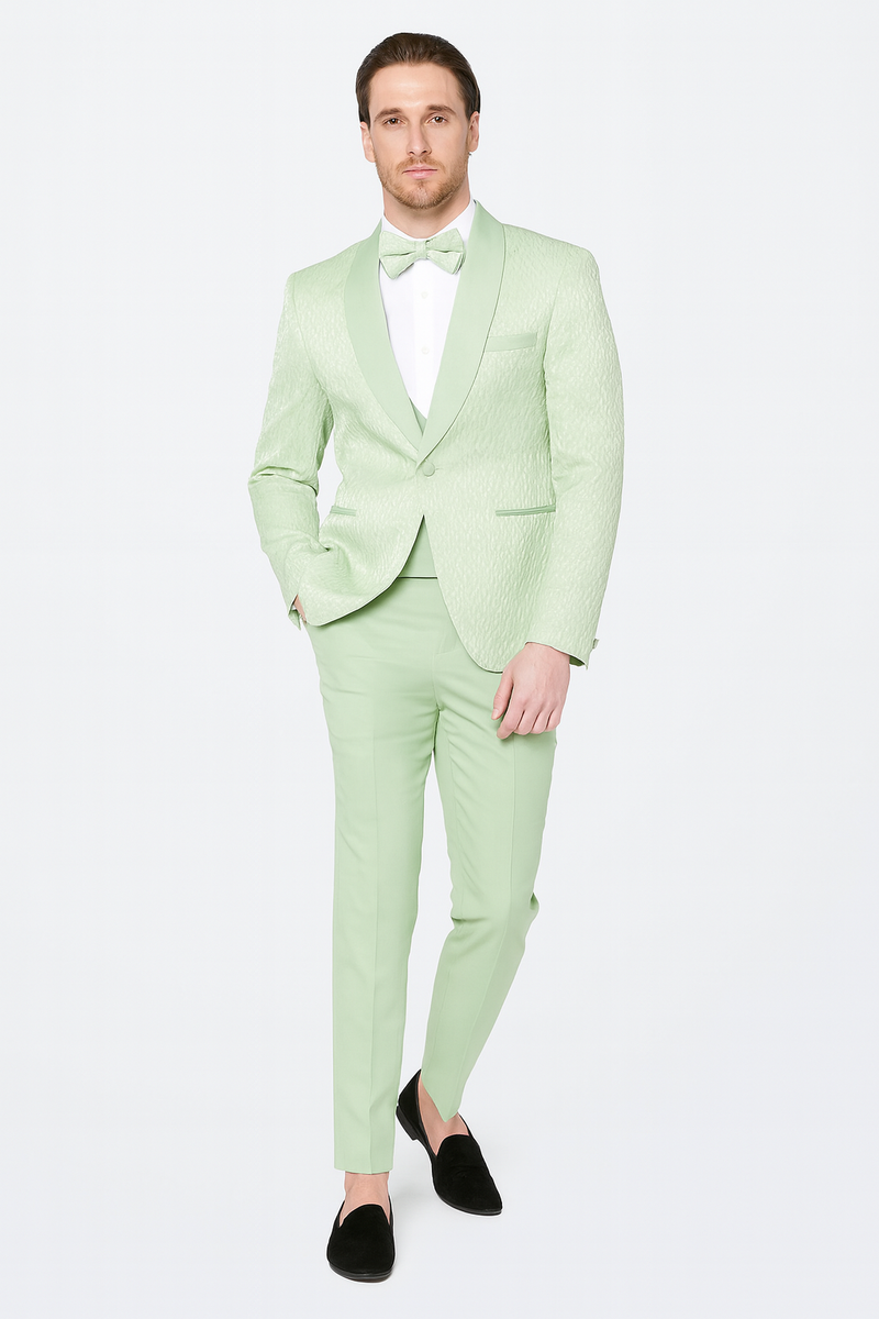 Men's mint green tuxedo suit with slim fit, shawl lapel, and sage green bow tie. Textured fabric in light green hue. Straight-cut trousers complete the look.