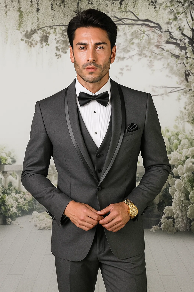 Men's charcoal satin shawl tuxedo suit. Fitted with shawl collar & satin finish. Vest visible. Includes white dress shirt & bow tie. Features front pockets, tailored for a polished look.