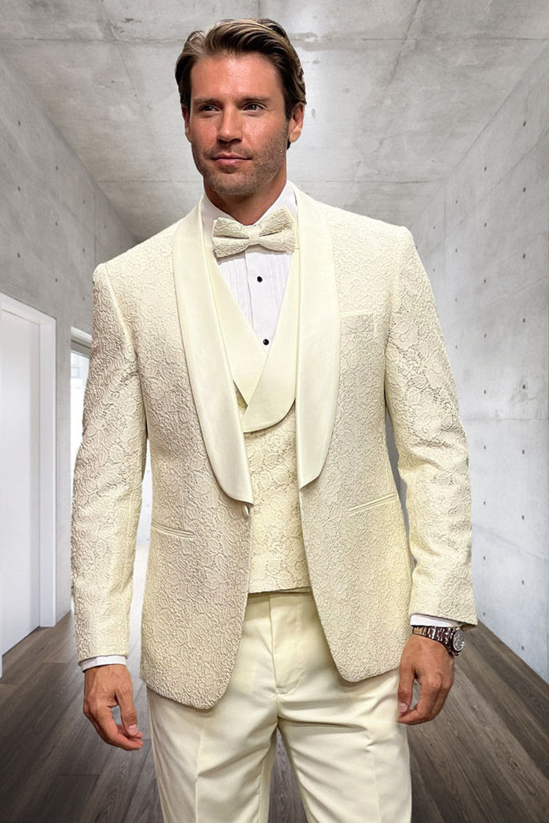 Ivory designer tuxedo with fitted shape & floral lace. Satin shawl collar, matching vest, & ivory trousers complete the elegant men's ensemble.