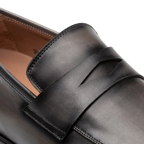 Dark grey Mezlan Avenue penny loafers. Smooth leather upper with classic penny slot design. Durable rubber sole. Visible stitching for structure and refined finish.