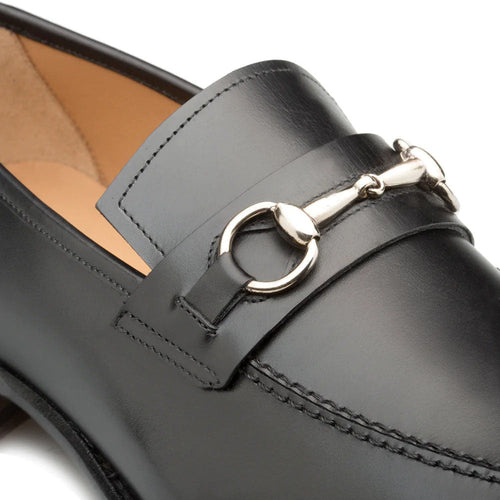 Black Mezlan leather loafers with rounded toe. Silver decorative bit on vamp. Visible stitching. Tan interior lining. Black outsole.