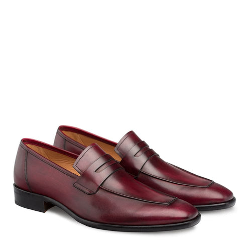 Burgundy Mezlan men's penny loafers crafted from calfskin. Elongated shape, slip-on design with a smooth finish and stitched toe detail. Features penny slot, stacked heel, black sole, and tan leather lining.