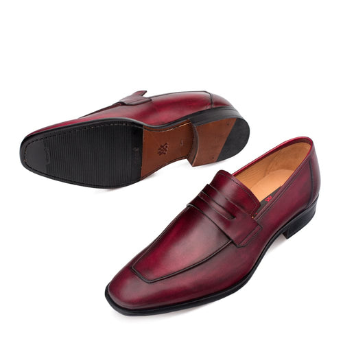Burgundy Mezlan men's penny loafers. Slip-on design crafted from polished calfskin with a rounded toe and penny strap. Features brown midsole, black rubber outsole, and streamlined shape.