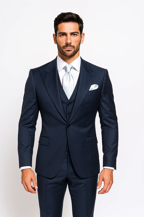 Classic navy suit: single-breasted, 3-button jacket with front pockets. White shirt, silver tie, pocket square. Paired with baggy, pleated, wide-leg wool pants.
