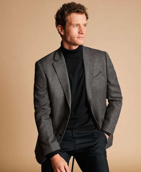 Men's grey tweed herringbone sport coat. Structured fit, notched lapel, single-breasted. Features two front pockets. Subtle grey herringbone pattern.