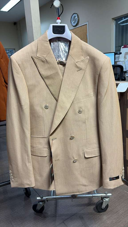 Vitali brand men’s beige double-breasted suit features a structured silhouette with wide peak lapels, two rows of buttons, and two front pockets. The fabric appears smooth with a light beige color.