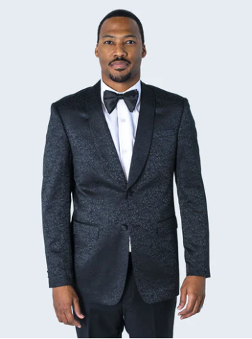 Men's black tuxedo suit. Fitted jacket with dark paisley floral texture, notch lapels, single-button closure. Matching trousers complete the look.