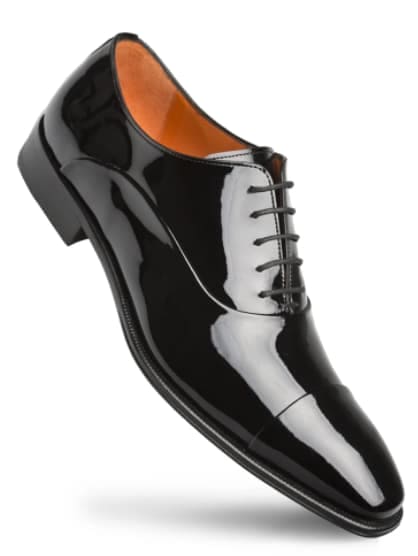 Black patent leather Oxford shoe. Polished surface, rounded toe, lace-up closure. Contrasting orange interior. Tapered black sole. Sleek and shiny.
