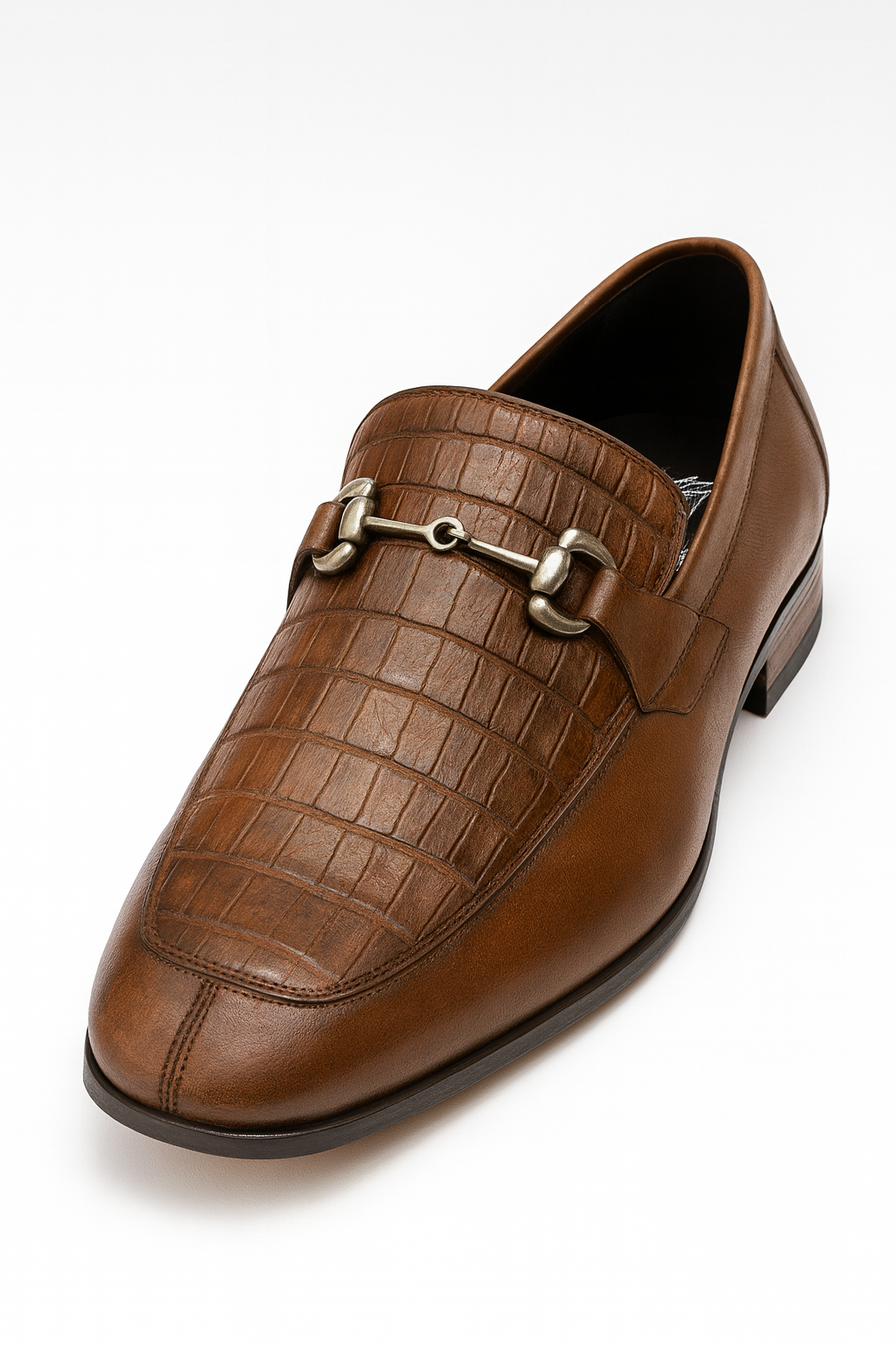 Men's regal brown slip-ons with a sleek, elongated shape and rounded toe. Smooth leather upper with crocodile pattern on the vamp. Metal strap detail. Low stacked heel, flat sole.