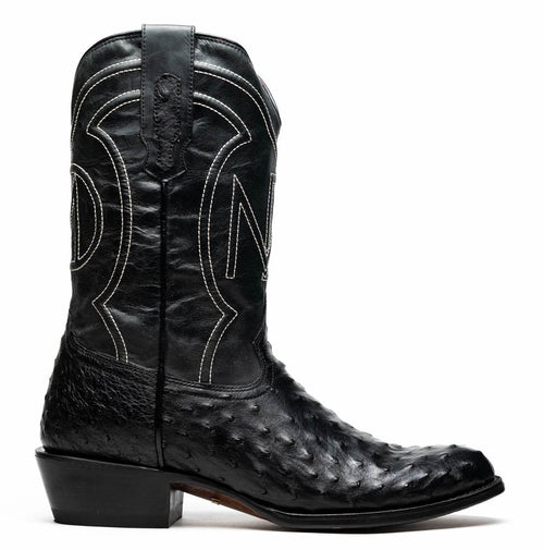 Marco Di Milano Savannah cowboy boots. Black ostrich quill leather upper with round toe & elevated heel. White stitched shaft detailing. Features pull tab.
