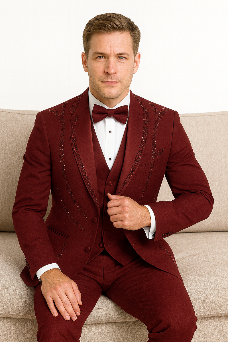 Men's burgundy Italian wool tuxedo. Modern 3-piece suit: fitted jacket with decorative stitching, vest, and trousers. Smooth texture, structured silhouette. Formal attire.