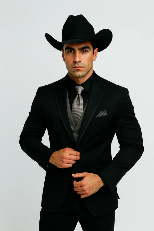 Men's black western tuxedo: fitted silhouette, smooth fabric. Silver vest & tie. Cowboy hat included. Classic western formal wear.