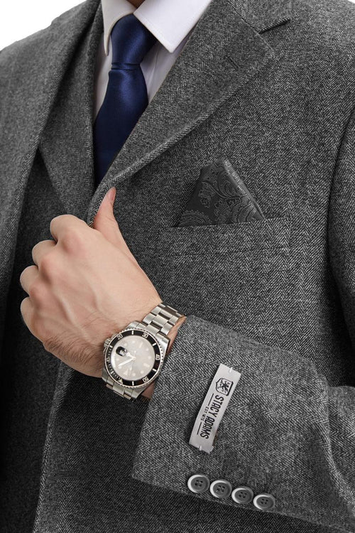 Stacy Adams men's grey herringbone tweed suit. Vintage-inspired with a tailored fit, single-breasted design, and functional cuffs. Features structured lapels and a pocket square. Likely wool or blend. Classic style.