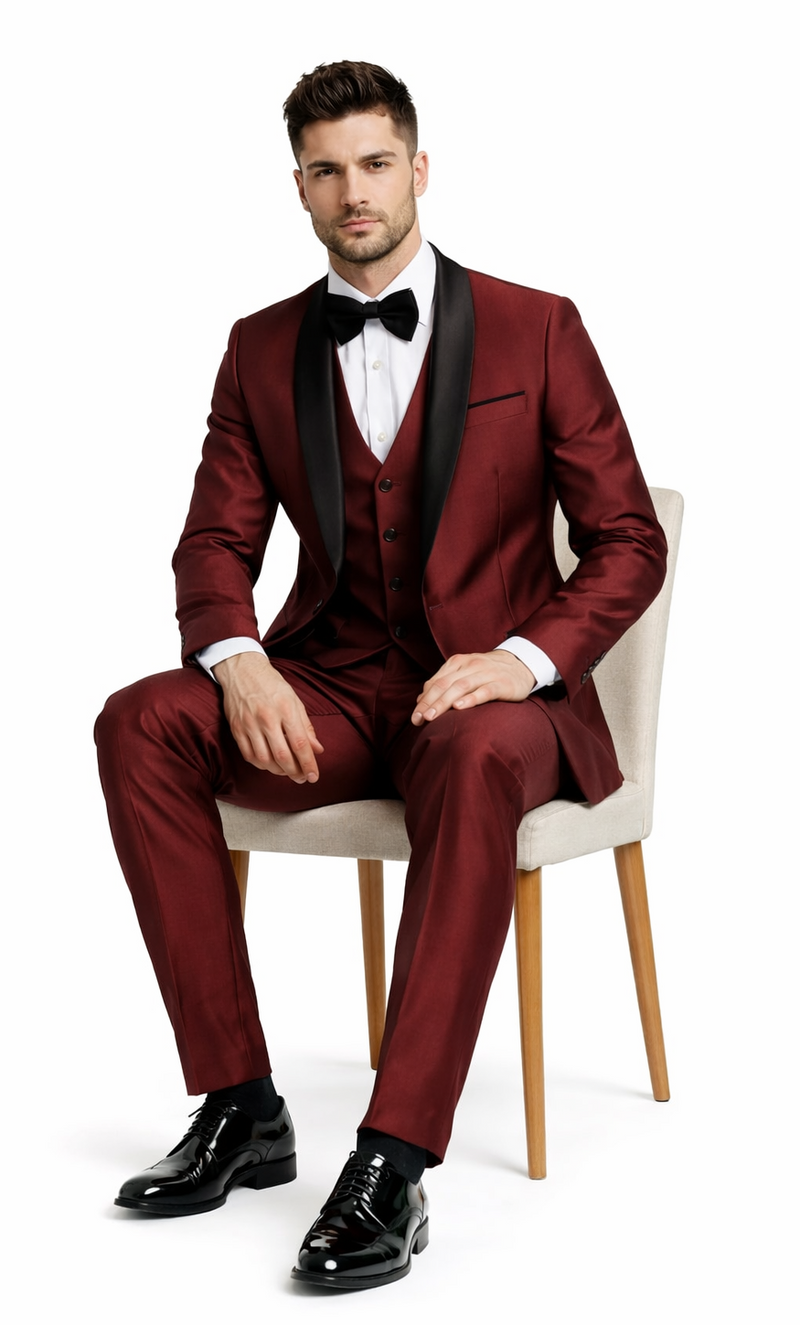Burgundy 3-piece tuxedo with a shawl lapel jacket, vest, and tailored trousers. Smooth, deep burgundy fabric. Black contrasting shawl lapel for a formal look.