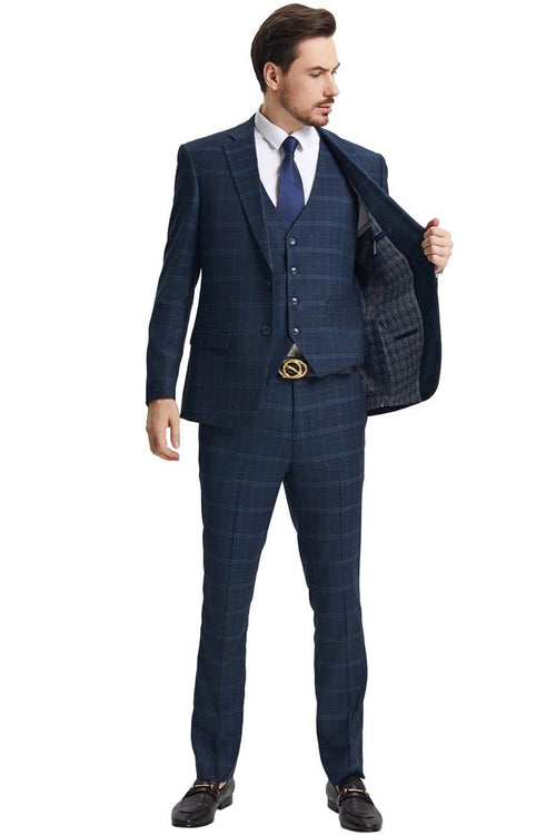 Navy blue suit featuring a modern fit design with a vested style and windowpane plaid pattern. The suit includes a structured jacket and tailored trousers.