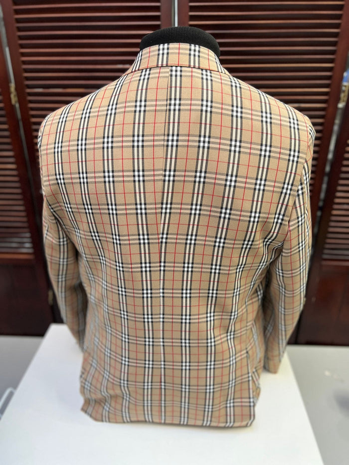 Beige checkered blazer with tan plaid, black/red accents. Lightweight fabric, structured silhouette. Classic collar, smooth back. Windowpane detail enhances texture.
