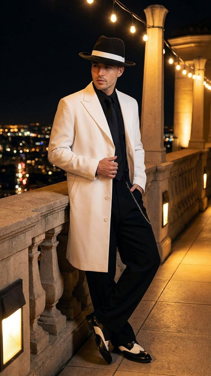 Men's white zoot suit gangster style outfit features a long white jacket with large lapels, a black shirt, and dark pants. The outfit is completed with black and white shoes.