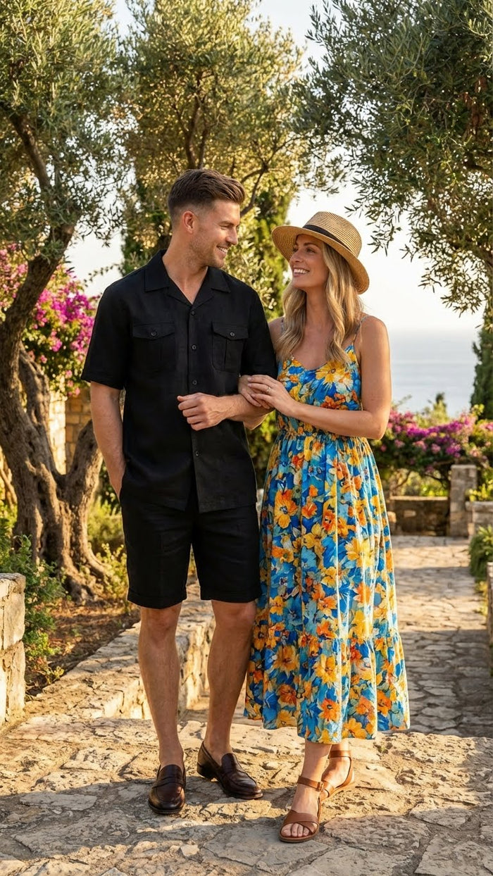 Men's black walking suit featuring a short-sleeved, button-up shirt with two chest pockets, accompanied by matching knee-length shorts. The material appears lightweight and may be fabric-based, uniform in its black color without patterns or embellishments.