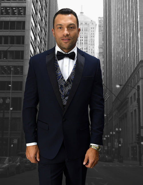Navy blue men's one-button wool tuxedo with notch lapels. Includes a patterned vest. Tailored fit, single-button closure, and dark navy wool. Vest features blue and white designs.
