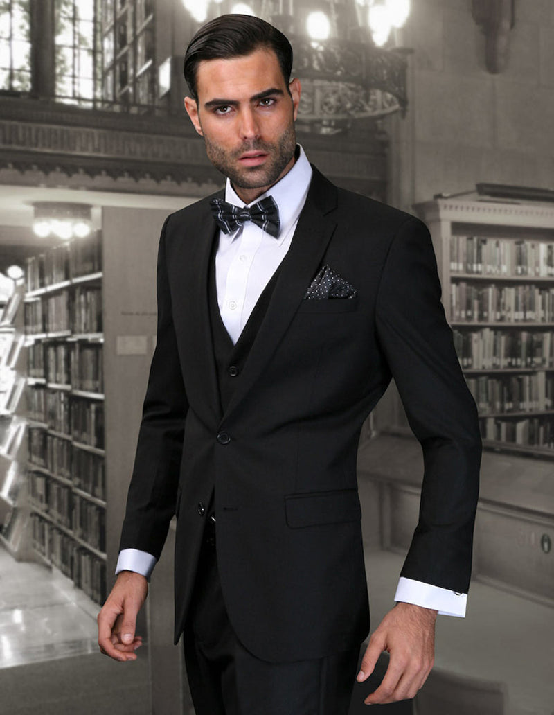 Black men's 2-button skinny wool suit with vest. Slim fit, solid black, notch lapel. Includes suit, vest. Worn with white dress shirt and bow tie.