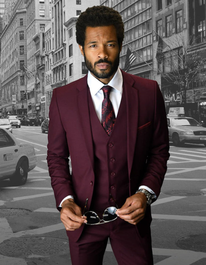 Men's burgundy skinny wool suit: 2-button jacket, matching vest, slim trousers. Fitted design, notch lapel, 5-button vest closure. Streamlined silhouette.