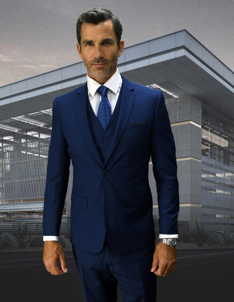 Men's sapphire blue, skinny fit wool suit. Includes jacket (2-button, notched lapel), vest, and trousers. Tailored for a modern, slim silhouette. Deep blue color.