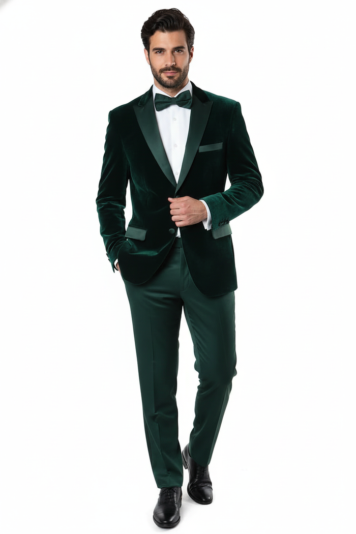 Dark green velvet tuxedo jacket. Single-breasted with peaked lapels & black satin trim. Features a left chest pocket and a soft, textured emerald green fabric. Classic design.
