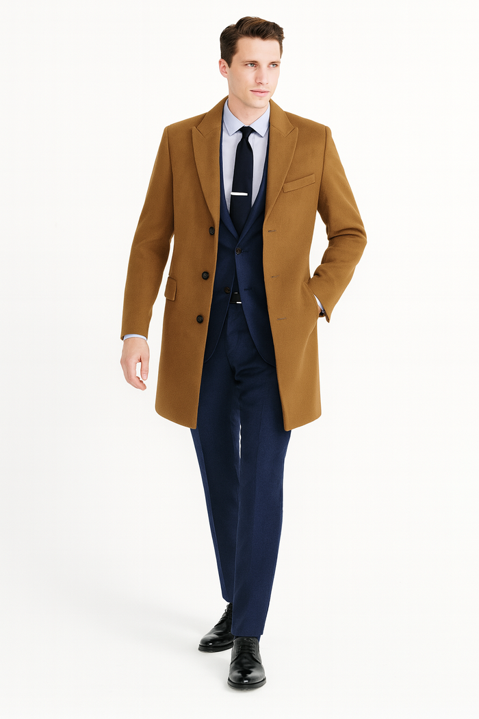 Men's camel brown wool overcoat. Straight silhouette, button-down front, notched lapels, and two front pockets. Single vent at the back.
