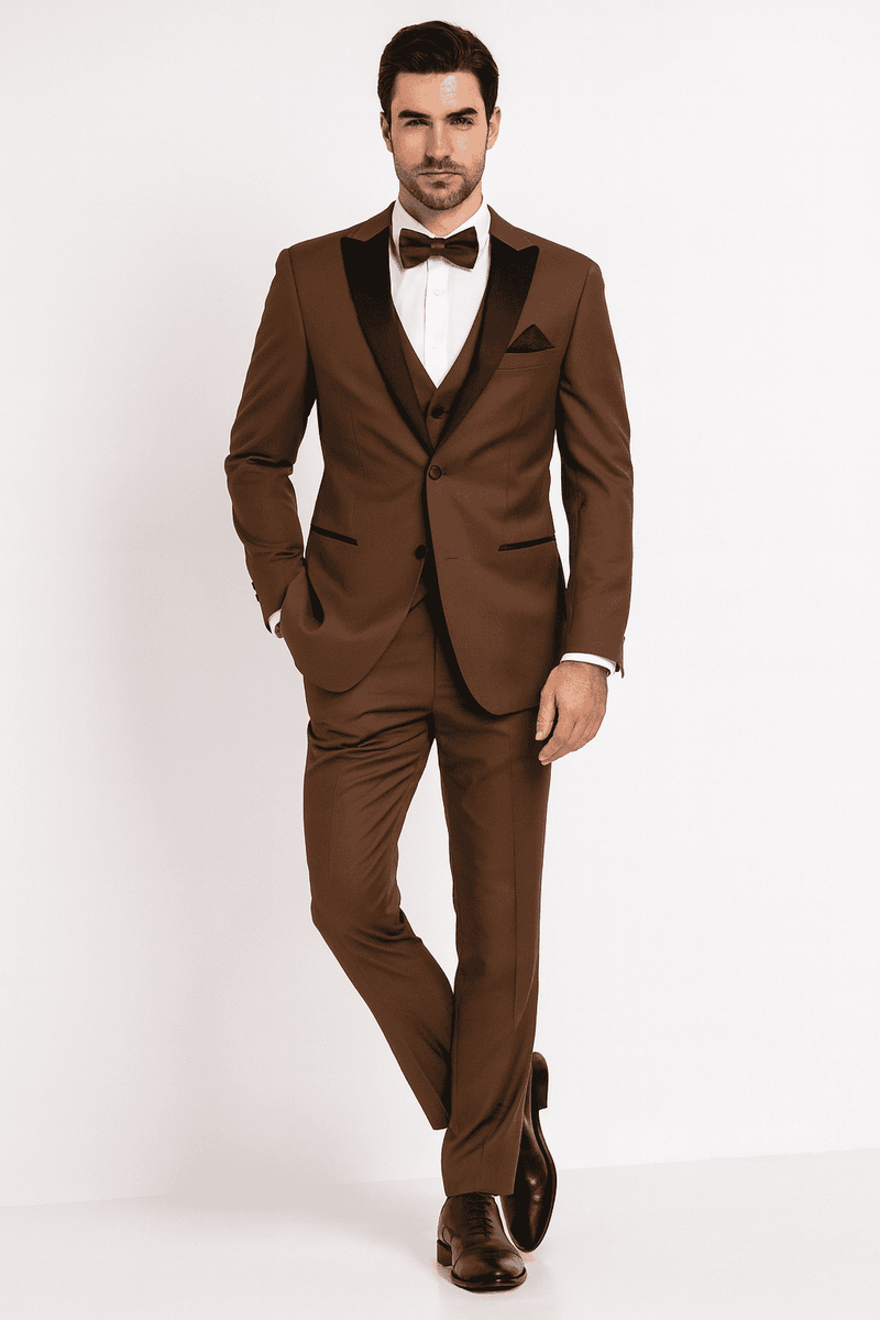 Men's light brown tuxedo suit with black satin lapel. Three-piece: jacket, vest, trousers. Smooth fabric, tailored fit, single-button jacket, pocket square, and matching bow tie.
